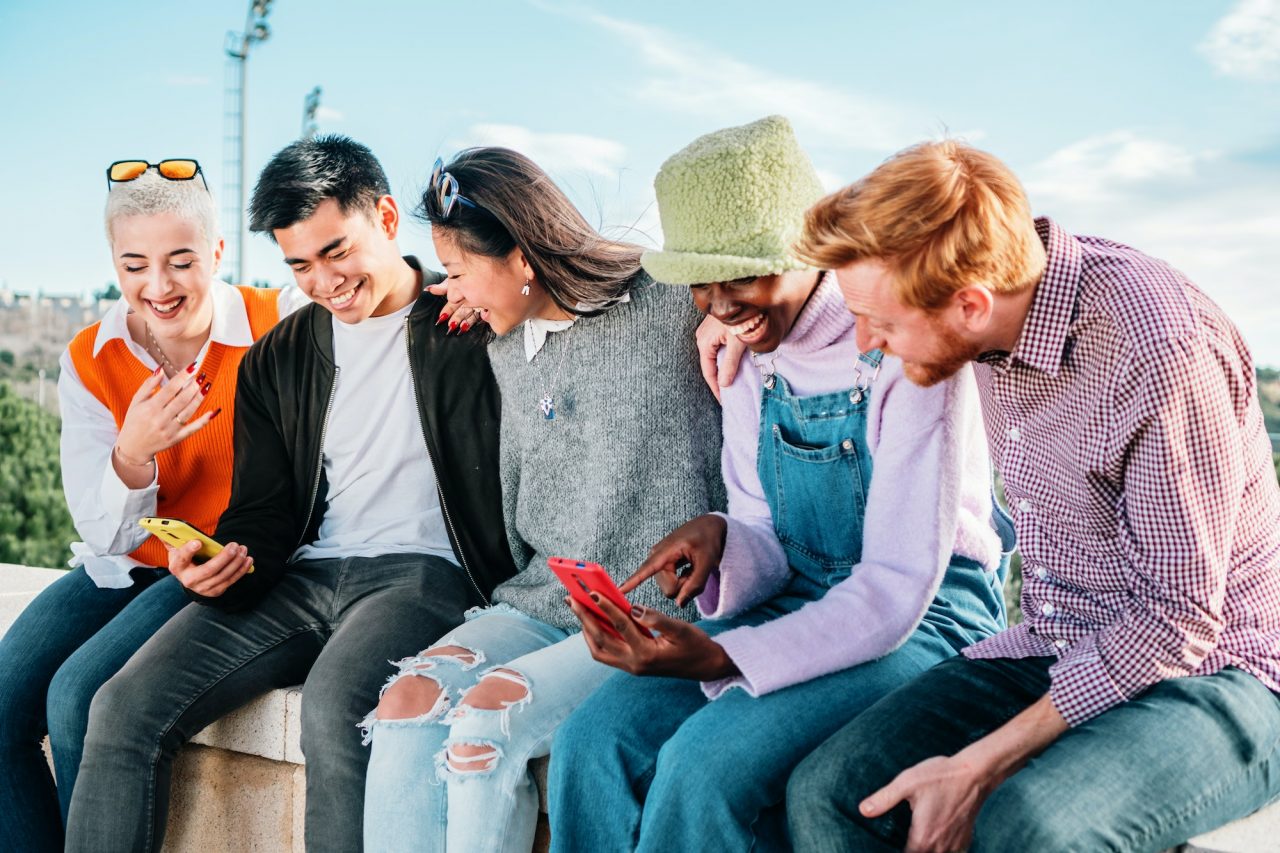 five-multiracial-friends-watching-videos-in-social-media-sitting-together-and-having-fun-.jpg